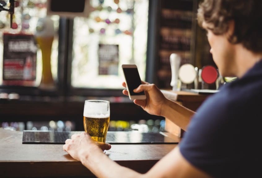 Una persona haciendo una foto a una cerveza para marketing para bares