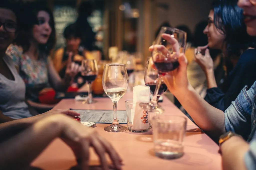 Gros plan d'une table dans un gastrobar : verres et personnes qui boivent.
